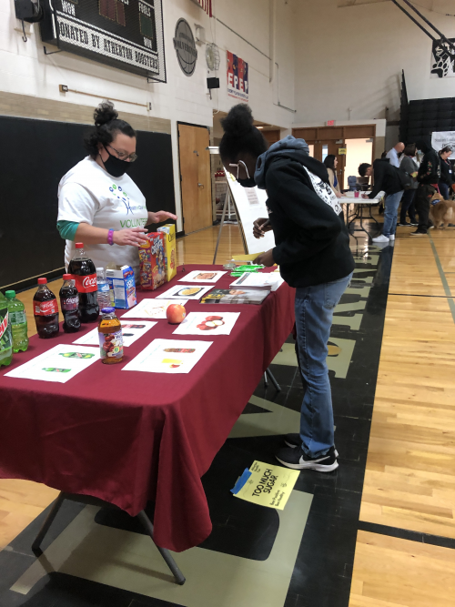 Too Much Sugar Maria Salinas Project Coordinator with Health in Our Hands engaging with a student